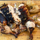 Grilled chicken cut up on a wooden cutting board